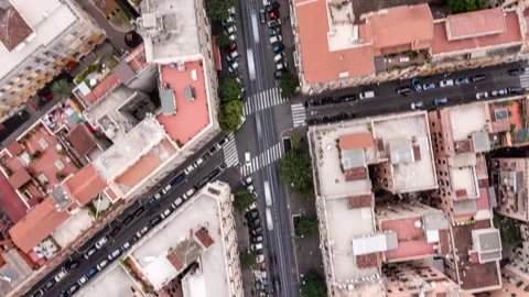 A Top-Down View Of A Vibrant Urban Intersection, Surrounded By Rooftops And Stock Footage 297723822