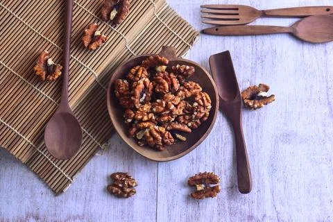Top down view walnut kernel halves in wooden bowl for snacking or baking. Stock Photos