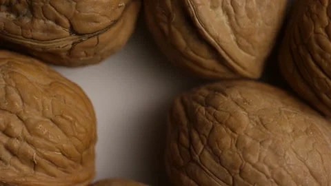 Top down view of walnuts rotating on white surface Stock Footage 328135530