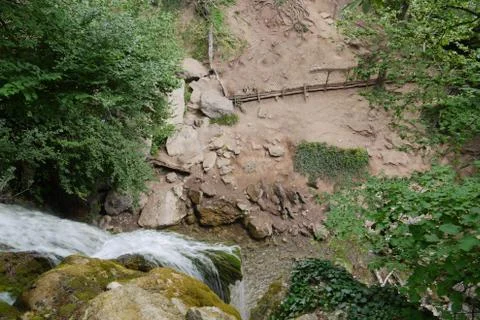 A top-down view of a waterfall flowing over rocks. Forming below a small pond Stock Photos