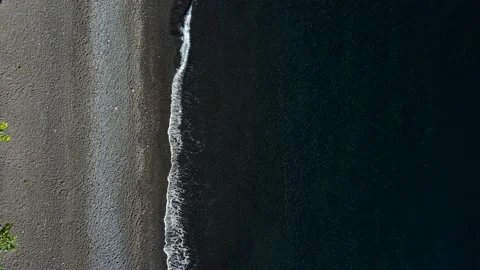 Top down view on waves on black sand beach Stock Footage 161782540