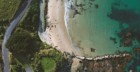 Top down view of waves breaking in the sand in Nugget Point Lighthouse, Otago Stock Photos
