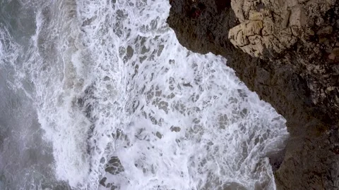 Top down view of waves crashing on a cliff of rocks. Rough dangerous medite.. Stock Footage 305067208