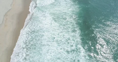 Top down view of waves crashing on a sandy beach The Concept of tranquility Stockbeeldmateriaal 333110942