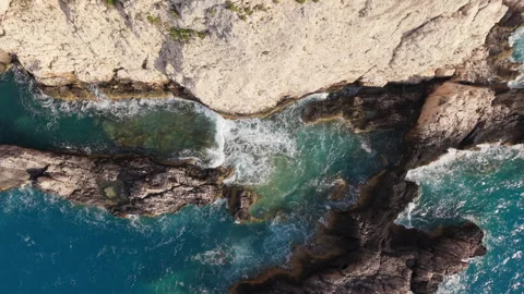 Top Down View of Waves Crashing Against Coastal Rocks Stock-Footage 335958627