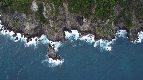 Top Down View of Waves Crashing Against Cliffs Stock Photos