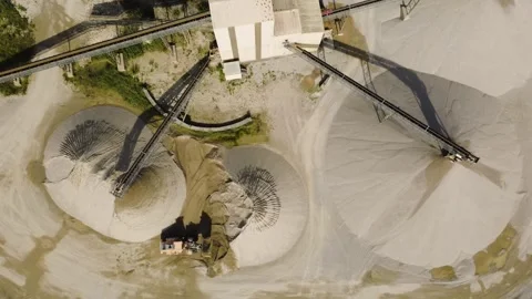 Top-Down View of a Wheel Loader and Conical Sand Stockpiles at a Gravel Plant Video stock 344105111