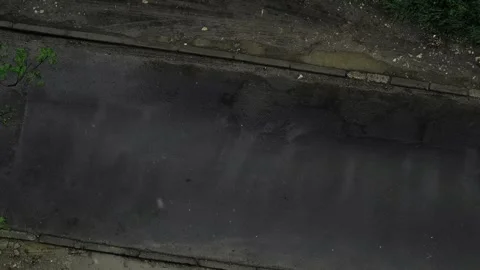 Top-down view of a white car driving on wet asphalt in the spring rain. Food and Stock Footage 276182964
