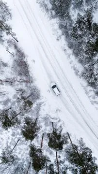 Top down view of white car on snowy road in winter forest Stock Photos