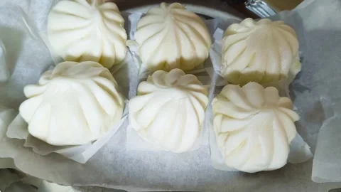 Top-down view of white Chinese steamed pork dim sum bao dumpling served on .. Video stock 318132587