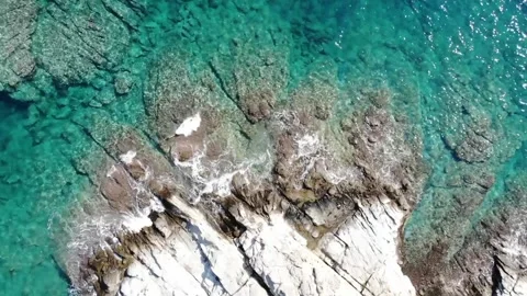 Top down view of white cliffs with crystal clear water in Kavala, Greece Stock Footage 143965843