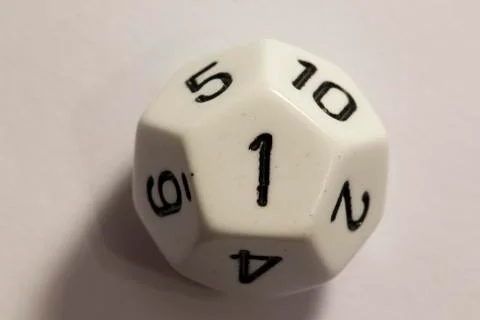 Top-down view of a white twelve sided die, showing a one Photos