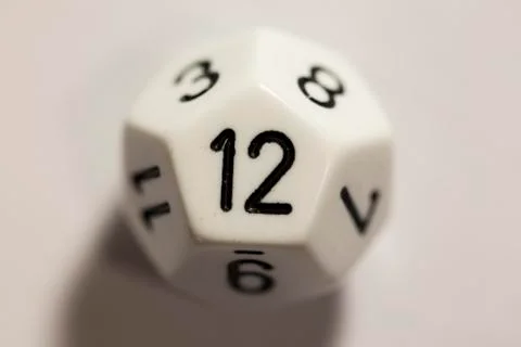 Top-down view of a white twelve sided die, showing a twelve 스톡 사진