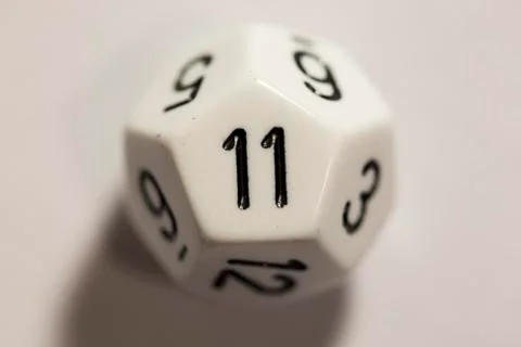 Top-down view of a white twelve sided die, showing an eleven 스톡 사진