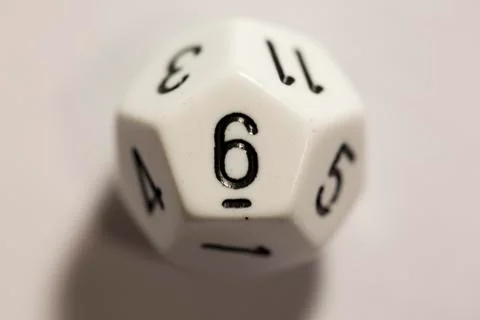 Top-down view of a white twelve sided die, showing a six 스톡 사진