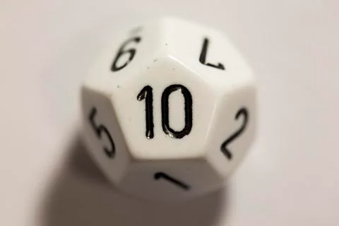 Top-down view of a white twelve sided die, showing a ten 스톡 사진