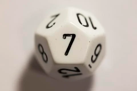 Top-down view of a white twelve sided die, showing a one 스톡 사진