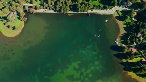 Top-down view of a winding reservoir inlet lined with small houses and farmland Stock Footage 346015218
