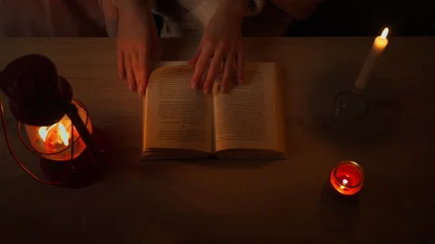 Top down view of woman hands turning pages of book on wooden table, illumin.. Stock Footage 325670681
