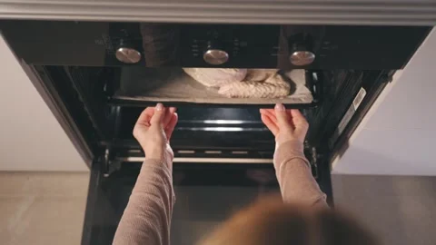 Top-down view of woman placing whole raw turkey on baking sheet into modern.. Stock Footage 343682067