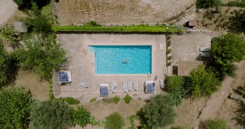Top down view of a woman in red swimsuit lying on her back in the pool. Stock Footage 210876196