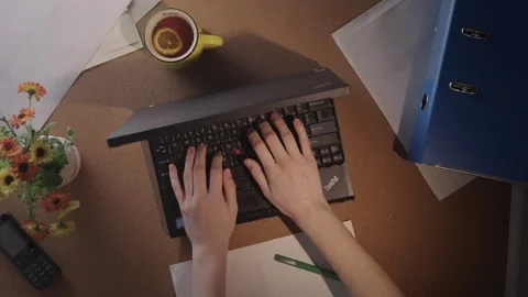 Top-down view of a woman typing on an old laptop Video stock 296331891