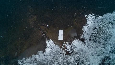 Top Down View of Wooden Dock and Winter Shoreline During Active Snow Storm Stock Photos