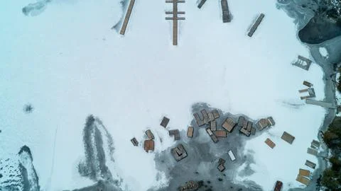Top Down View of Wooden Docks and Marina Frozen in Lake Ice in Winter Thaw Foto stock