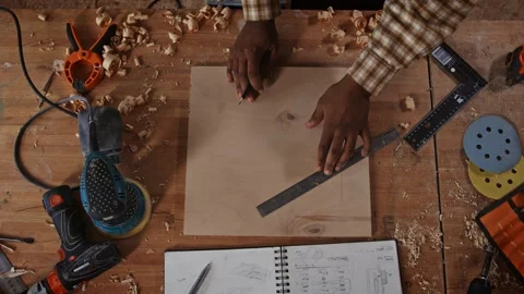 Top down view of woodworker measuring marked board with tools arranged on a Video stock 343897487