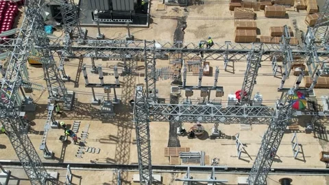 Top-down view of workers constructing an electrical substation Stockbeeldmateriaal 278367894