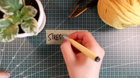 Top down view of writing STRESS RELIEF on masking tape with cozy accessories Stock Footage 338183813