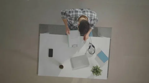 Top-down view of young man closing laptop after finishing work, putting on .. Stock Footage 337519158
