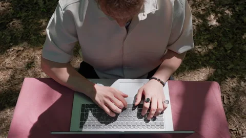 Top-Down View of Young Man Typing on Laptop Outdoors Stock Footage 339031226
