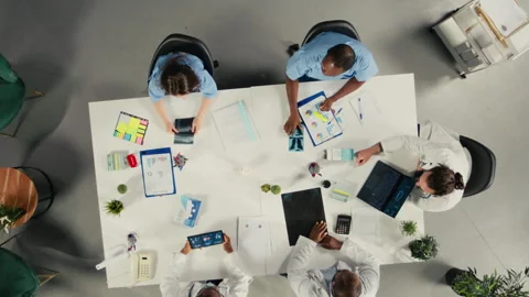 Top down view zoom in of surgeons staff in a clinic discussing therapy options Video stock 320033146