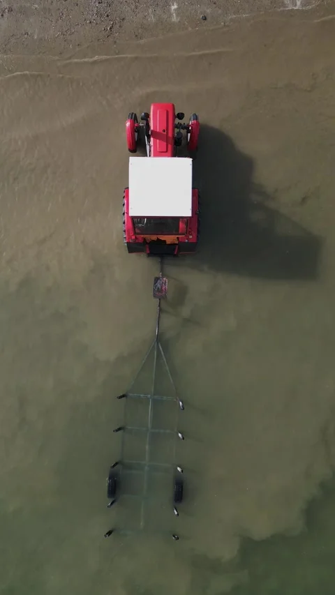 Top-Down Vintage Red Tractor Submerged in River - Nostalgic Wreckage in Water Stock Footage 330495338