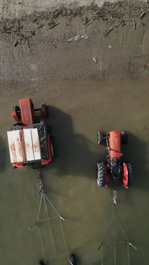 Top-Down Vintage Red Tractor Submerged in River - Nostalgic Wreckage in Water Stock Footage 330495407