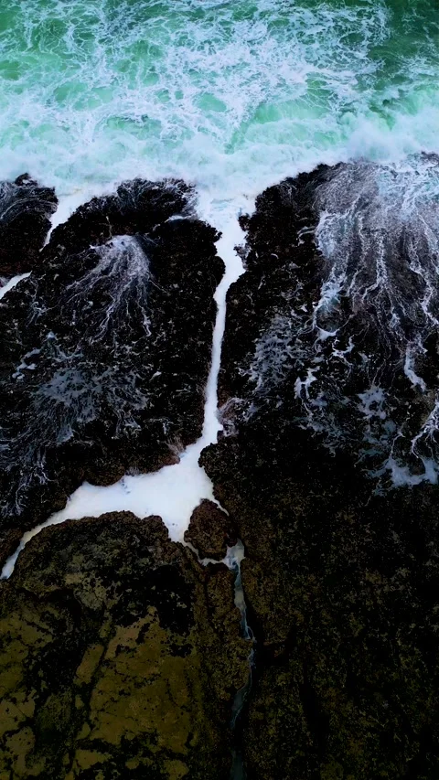 Top Down Waves Crashing on Dark Rocks Stock Footage 329097146