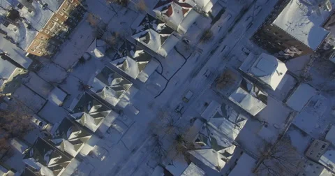 Top-down winter view of snow-covered houses and narrow neighborhood streets Stock Footage 60019681