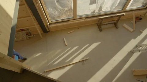 TOP DOWN: Worker coming to work carries his toolbox and ladder across the room. Stock Footage 125040716