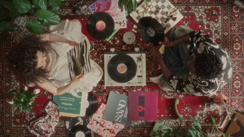 Top Down of Young Couple Selecting and Playing Vinyl Records on Retro Turntable Stock-Footage 339850655