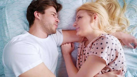Top down zoom out happy young man and woman in bed in the morning Video stock 110779839