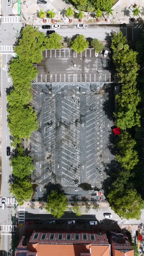 Top down zooming in shot of empty car park with greenery trees around. Cleared Stock Footage 254577811