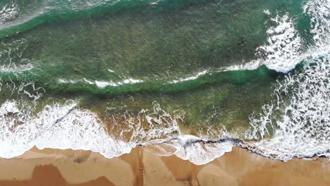 Top drone view of clear sea waves crashing on sandy seashore,nature slow motion Stock Footage 235544713