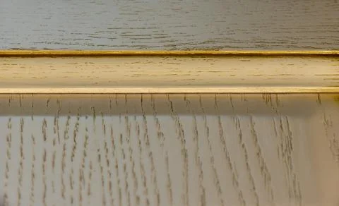 Top edge of white classic kitchen facade with gilding and texture close-up. b Stock-Fotos