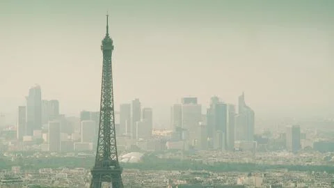 Top of the Eiffel Tower and distant skyscrapers of La Defense business district 写真素材