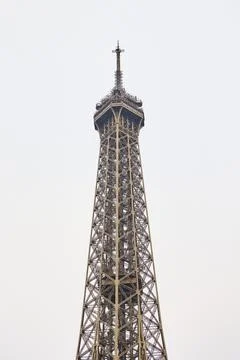Top of the Eiffel Tower in Paris against cloudy sky Stock Photos