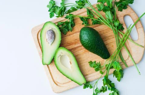 Top flat lay view of fresh organic vegetables on wooden cutting board with co Stock Photos