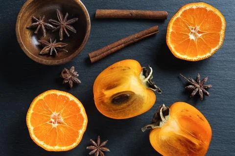 Top flat view: persimmon and tangerine, anise star, cinnamon sticks Stock Photos