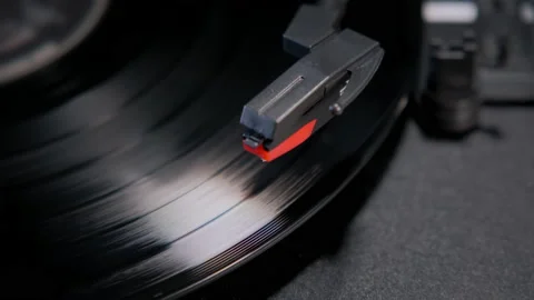 Top fooage of hands placing the vintage turntable on a spinning vinyl record. Stock Footage 233375091
