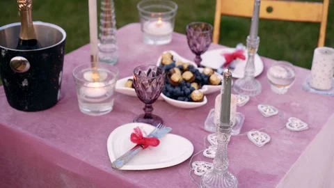 Top frame of the table romantically decorated on the green meadow with silver Stock Footage 155627639